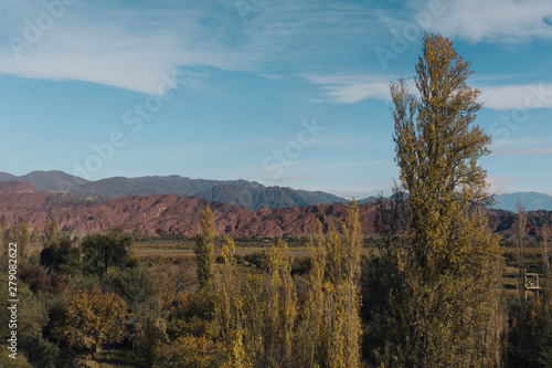 Autumn forest and mountains landscape with blue sky