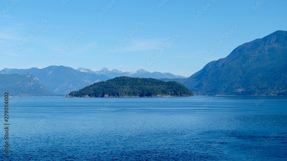 sea and island in front of mountain range