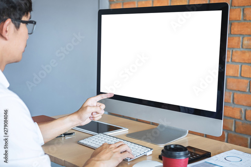 Image of Young man working in front of the computer laptop looking at screen with a clean white screen and blank space for text and hand typing information on keyboard in modern workspace