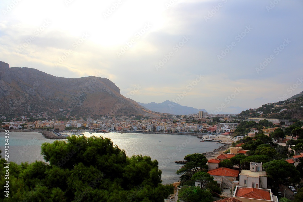 Fototapeta premium evocative image of maritime coast at sunset with fishing village in the background in Sicily, Italy