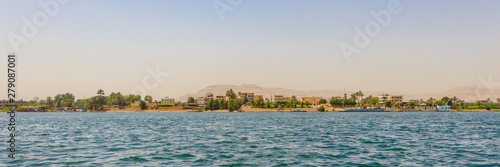 Residential buildings on the Nile river with sailboats in Luxor, Egypt