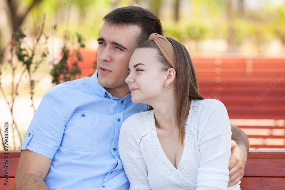 Young couple sitting on bench in park. Young couple sitting on bench in park.