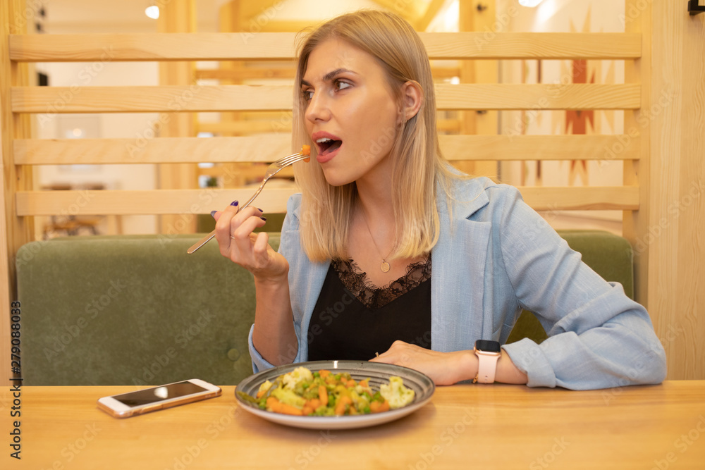 Woman eating salad in a cafe.
