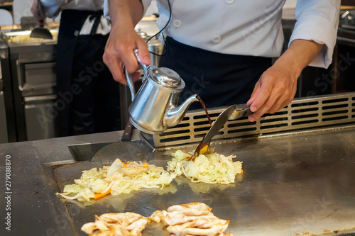 Japanese chef cooking meat and vegetable in teppanyaki restaurant