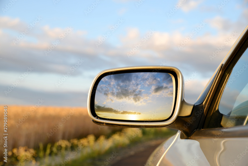 Sunset sky reflect in rearview mirror of car. - obrazy, fototapety, plakaty 