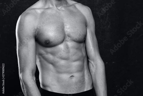 muscular man with naked torso on black background