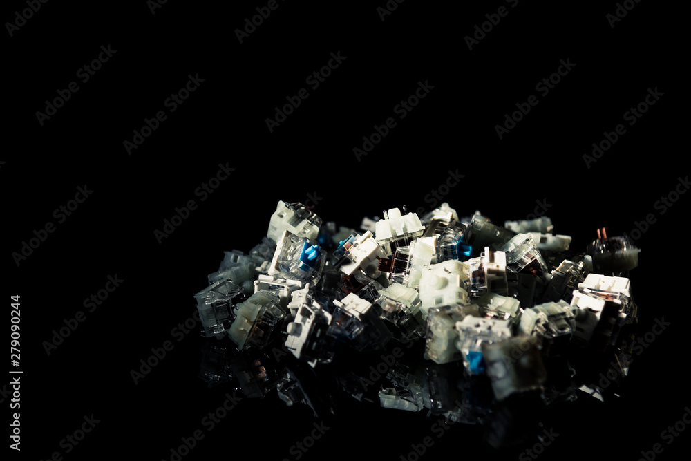Various mechanical keyboard switches, black background with reflection. Various mechanical keyboard switches, black background with reflection.