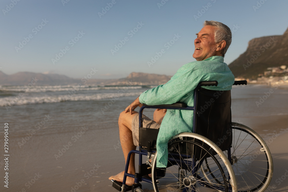 Disabled senior man smiling at beach