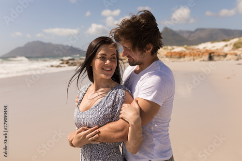 Romantic happy young couple embracing on beach