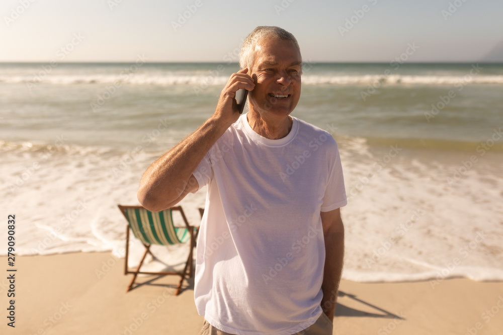 Senior man talking on mobile phone at beach Senior man talking on mobile phone at beach