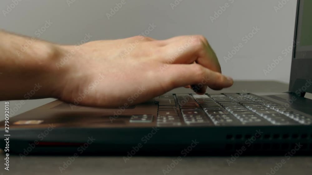 Man writes fast on notebook keyboard with all fingers. Side view. Man writes fast on notebook keyboard with all fingers. Side view.