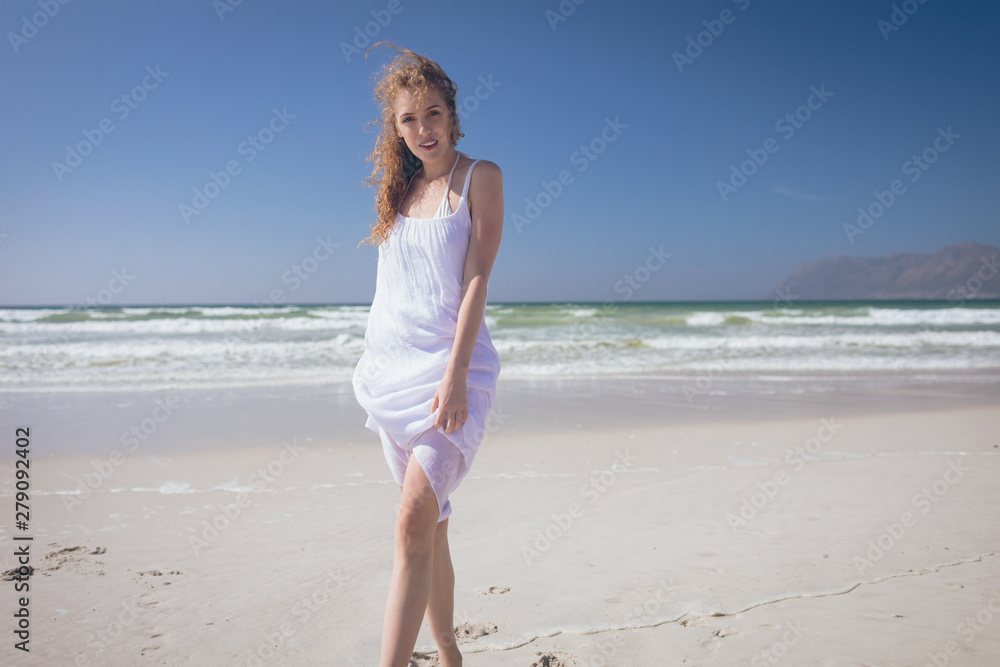 Beautiful woman giving pose while standing at beach Beautiful woman giving pose while standing at beach