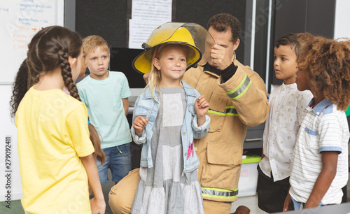 Foto Firefighter teaching student about fire safety in classroom