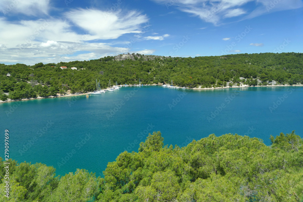 Natural small harbour with blue sea water and pine trees, Croatia