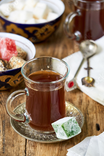 Glass of black tea and turkish delight on wooden background