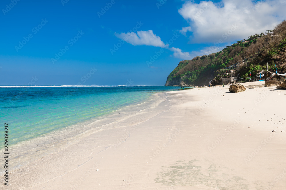 Tropical beach with white sand, blue ocean and waves