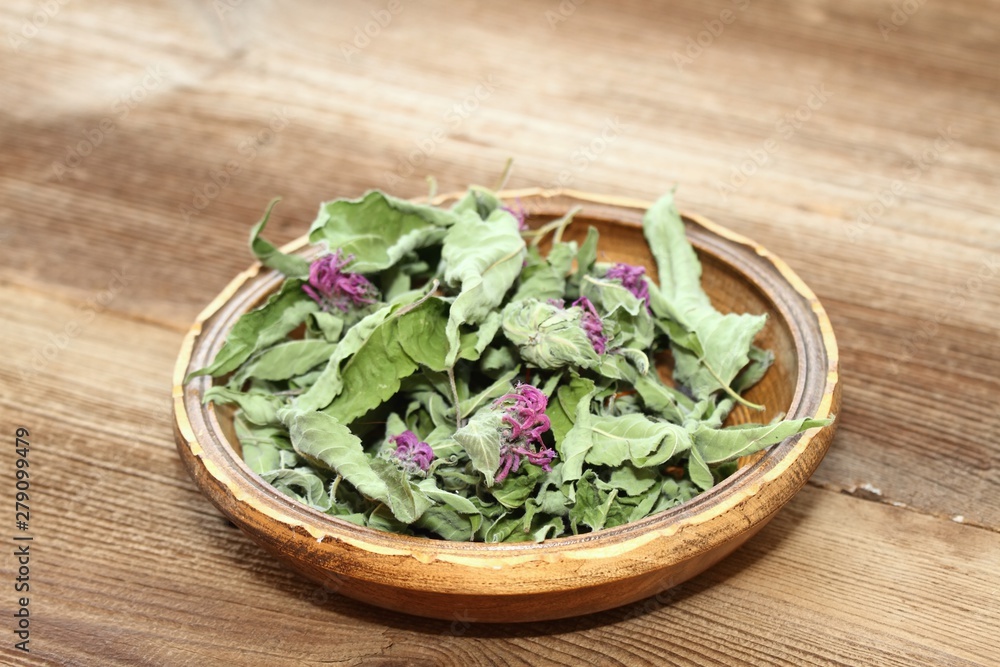 Bowl of dried bergamot. Flowers of bergamot, Monarda didyma, on woodem board Bowl of dried bergamot. Flowers of bergamot, Monarda didyma, on woodem board
