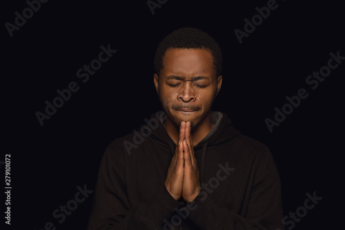 Canvas Print Close up portrait of young african-american man isolated on black studio background