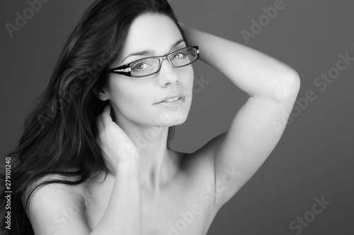 Portrait d'une très jolie jeune femme avec des lunettes en studio