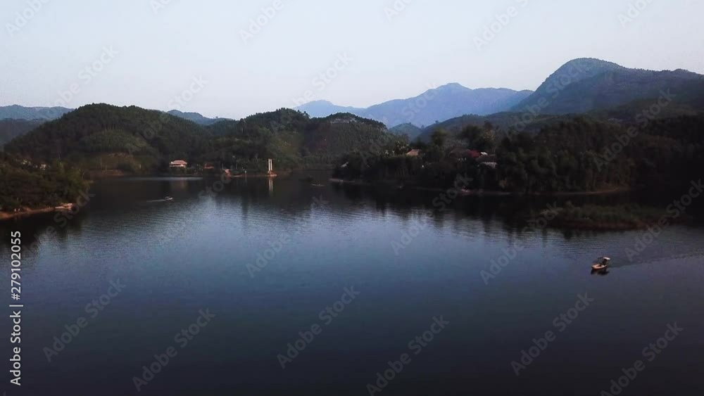 early morning flyover the many small islands in the Thac Ba lake, Vu Linh, Vietnam. Aerial drone dolly in establishing shot