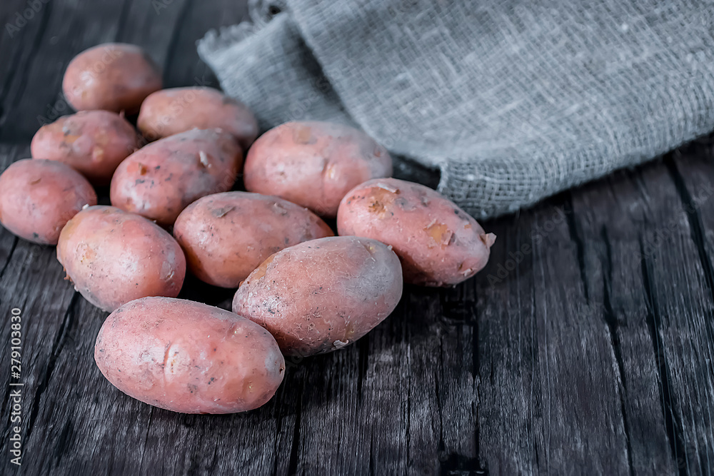Fresh organic potatoes on a brown wooden table. Fresh organic potatoes on a brown wooden table.