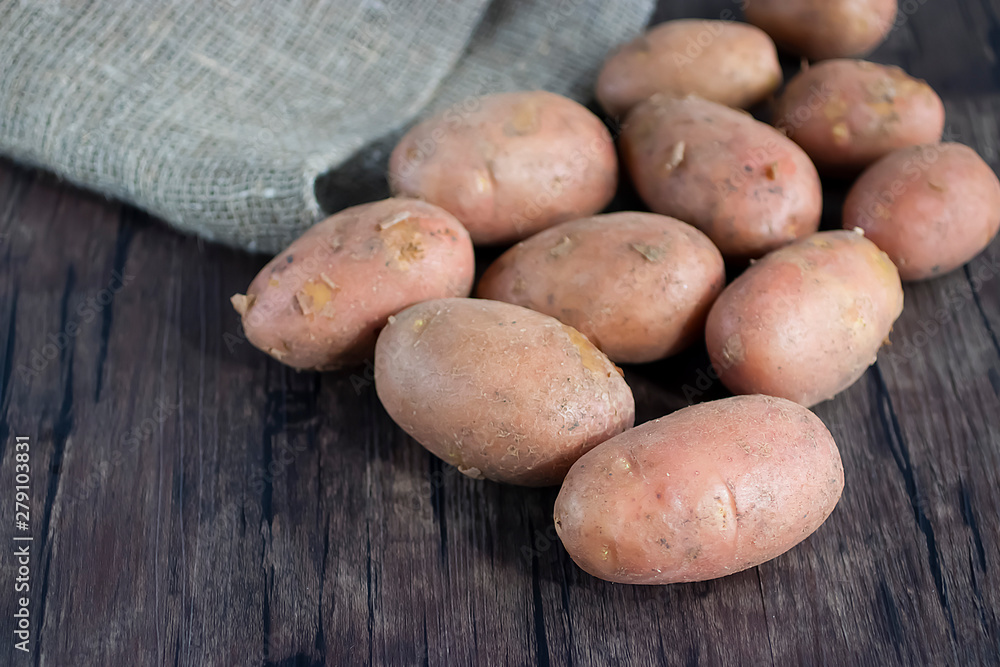 Fresh organic potatoes on a brown wooden table. Fresh organic potatoes on a brown wooden table.