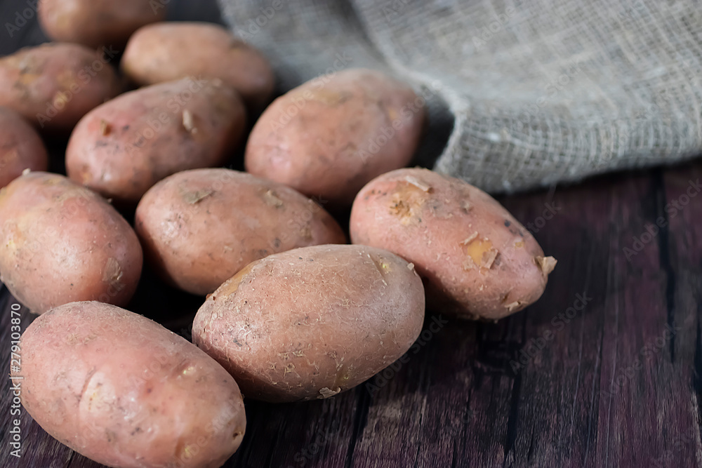 Fresh organic potatoes on a brown wooden table. Fresh organic potatoes on a brown wooden table.