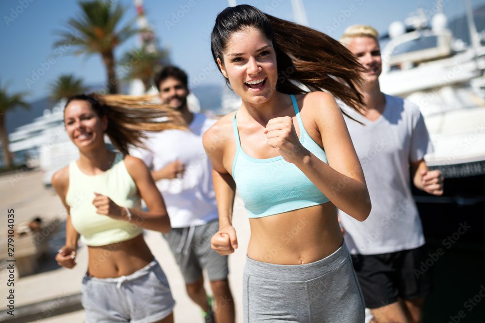 Running, friends, sport, exercising and healthy lifestyle concept. Happy people jogging outdoor.