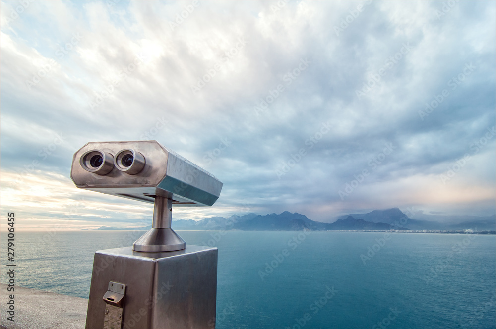 Binocular viewer next to the waterside promenade Binocular viewer next to the waterside promenade