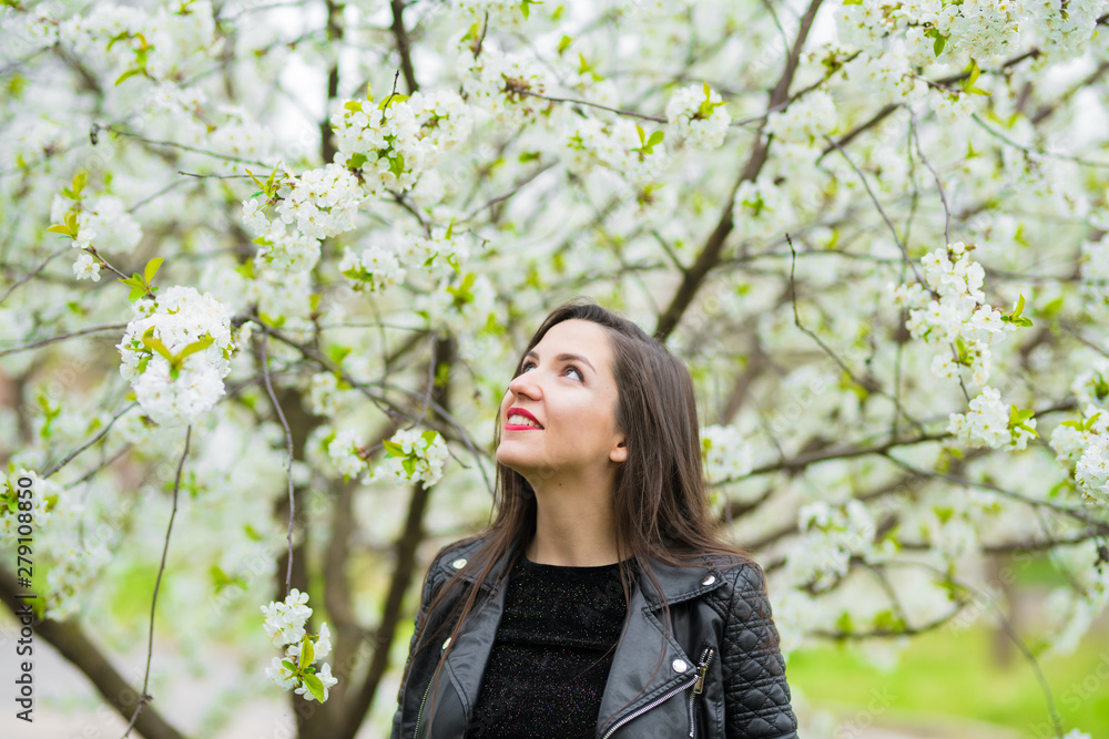 Pregnant girl in the flowered garden. beautiful pregnant girl in a black dress is standing in a flowered garden Pregnant girl in the flowered garden. beautiful pregnant girl in a black dress is standing in a flowered garden