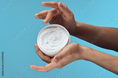 young woman applying moisturizer cream