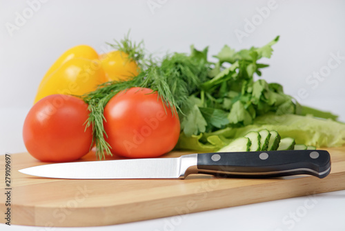 Chopping board with tomato  parsley and knife