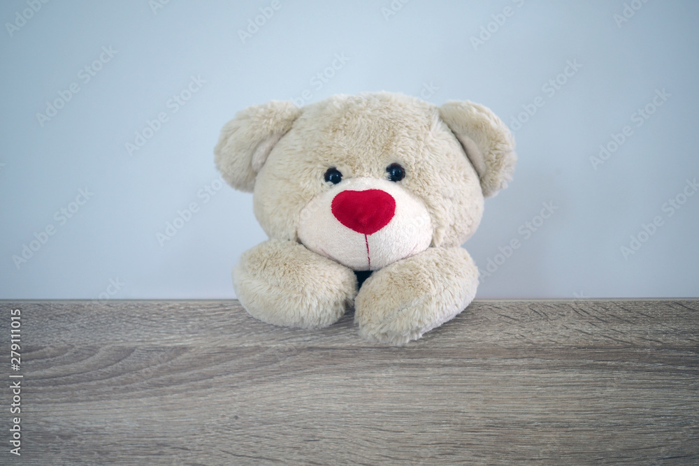 Obraz premium Background for kids play Teddy bear. Brown hair teddy bear standing behind the wood. Children's play concept