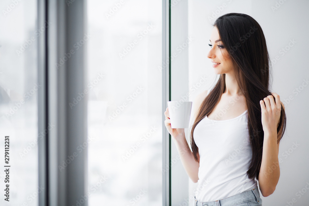 Beautiful woman standing near windows. Beautiful morning. Beautiful woman standing near windows. Beautiful morning.