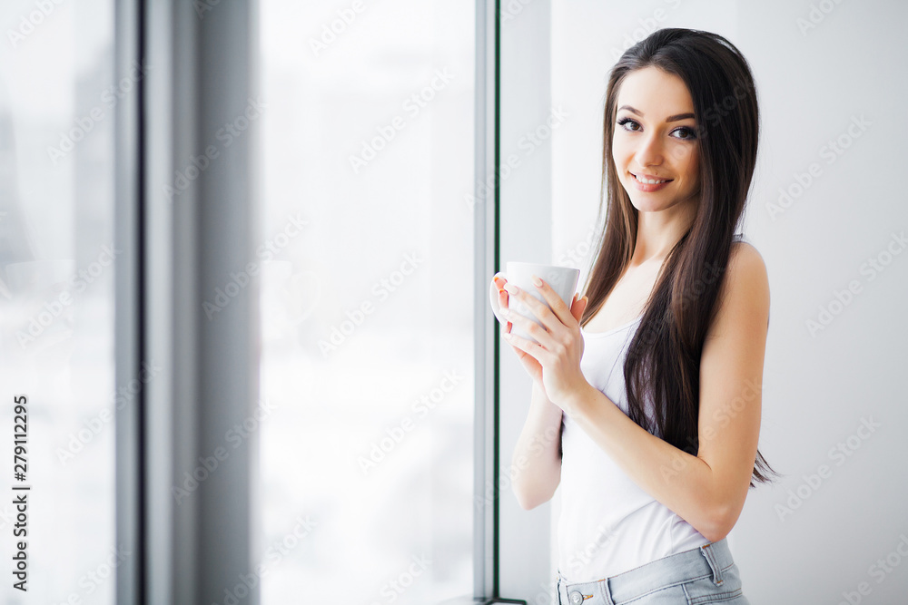 Beautiful woman standing near windows. Beautiful morning. Beautiful woman standing near windows. Beautiful morning.