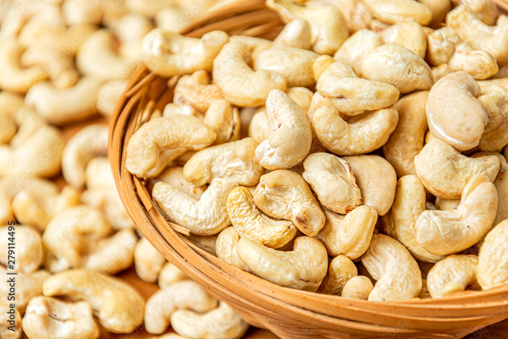 Close-up on healthy cashew nuts in a wicker bowl. Food photography. Healthy fresh cashew nuts. Minimalist photography. The Latin name of cashew is Anacardium occidentale. Close-up on healthy cashew nuts in a wicker bowl. Food photography. Healthy fresh cashew nuts. Minimalist photography. The Latin name of cashew is Anacardium occidentale.