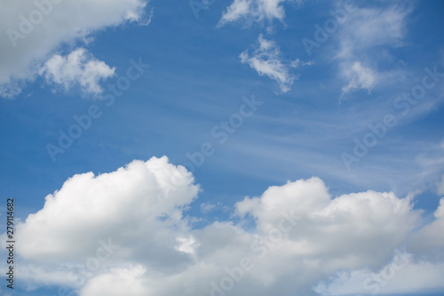 Sky with cumulus clouds. The background is blue and white. Bright day. Copy space. The frame of the clouds.