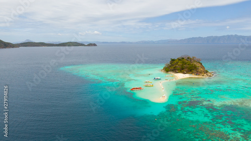 Island with a sand spit and coral reefs. Clear transparent sea near the island Bulog Dos aerial view. Philippines, Palawan