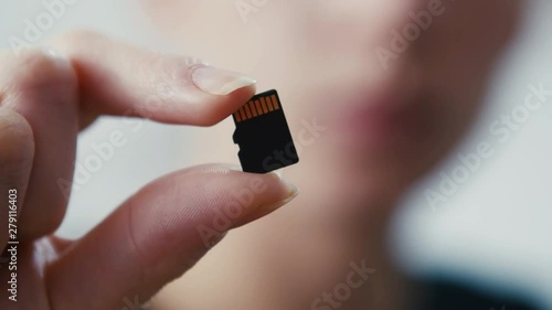 Tiny micro sd card storage held in hand, close up shot photo