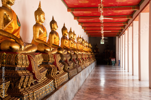 Close up of golden aligned Buddha statues in a temple