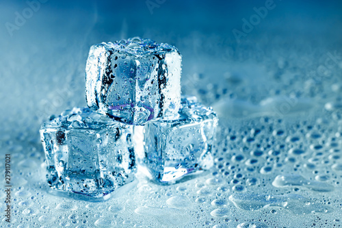 Ice cubes and water melt on cool background. Ice blocks with cold drinks or beverage.