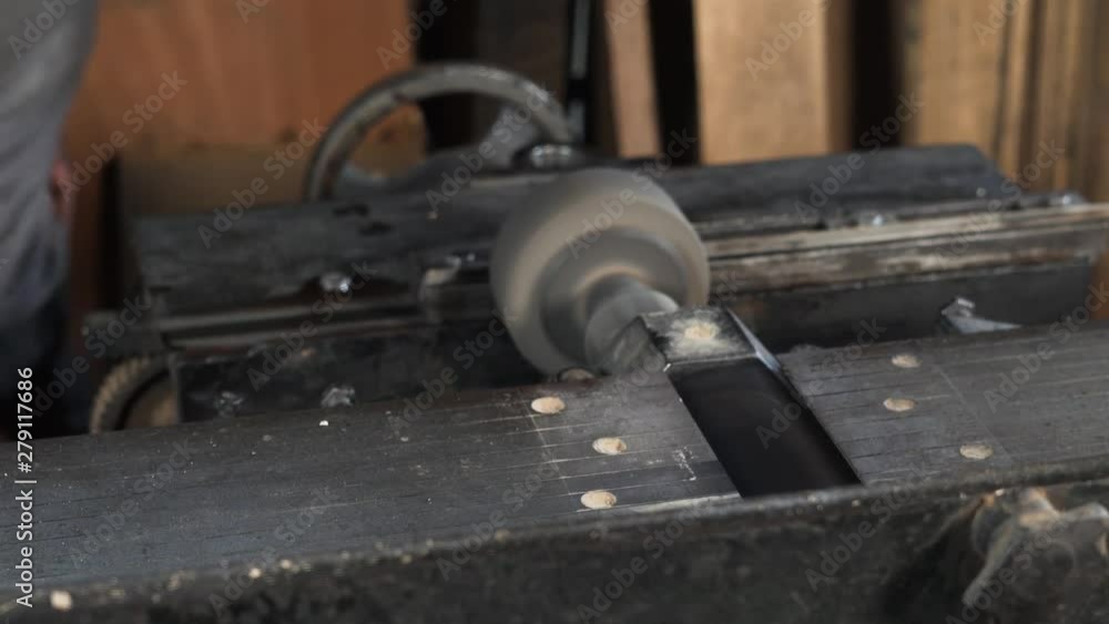 Working person in his work place: labourer operating a machine and he is sharpening a metal detail in a fabric Working person in his work place: labourer operating a machine and he is sharpening a metal detail in a fabric