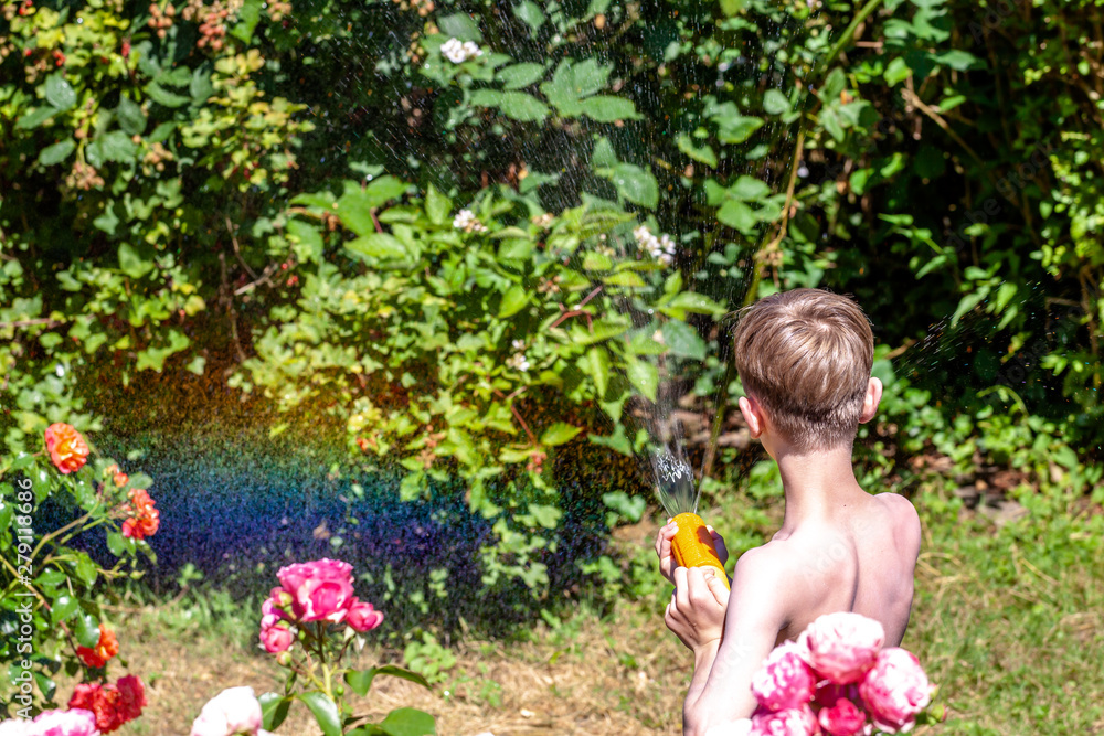 Happy little boy having fun with squirt gun in the garden Happy little boy having fun with squirt gun in the garden