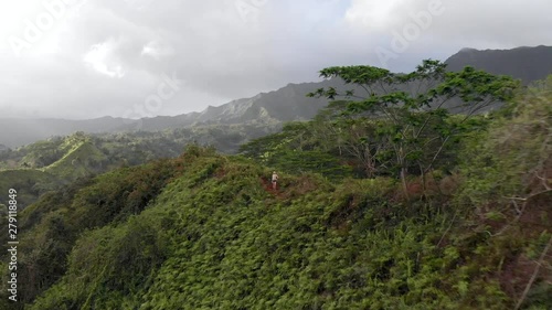 Version One, Girl Stationary. Aerial Flyover of Girl on Mountain Ridge in Hawaii, with Beautiful Panoramic View. photo