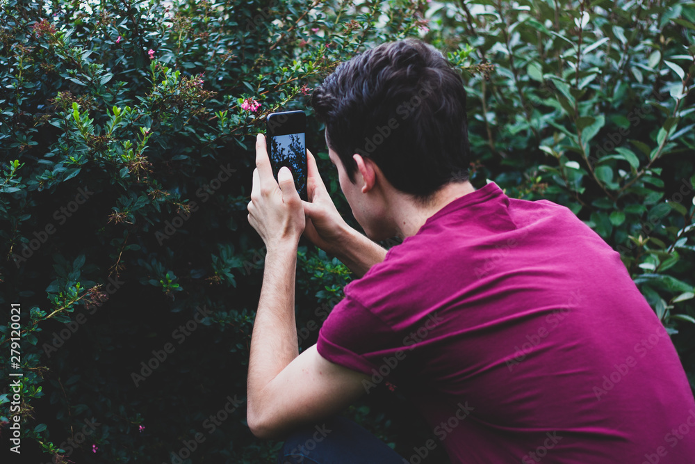 Man taking picture of flowers with a phone Man taking picture of flowers with a phone