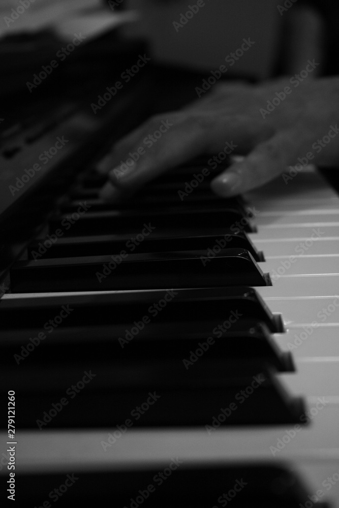 Hand playing piano perspective in black and white