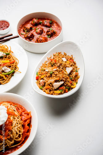 Assorted Indo chinese food in group includes non vegetarian or chicken Schezwan/Szechuan hakka noodles, fried rice, manchurian, egg american chop suey, soup with spoon and chop sticks, selective focus