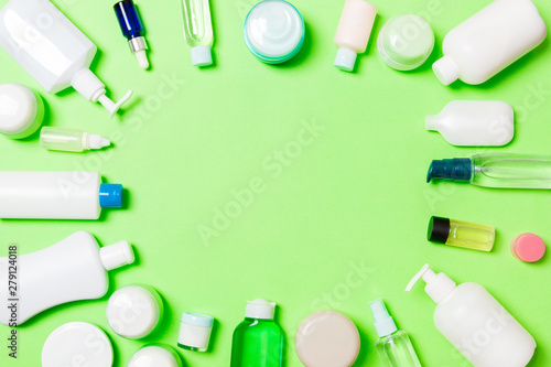 Frame of plastic bodycare bottle Flat lay composition with cosmetic products on green background empty space for you design. Set of White Cosmetic containers, top view with copy space