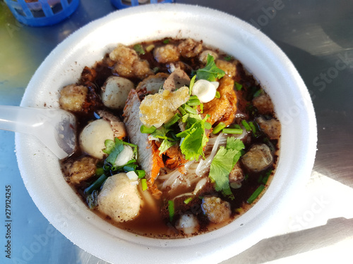 Close up of a bowl of Thai style pork noodle soup.