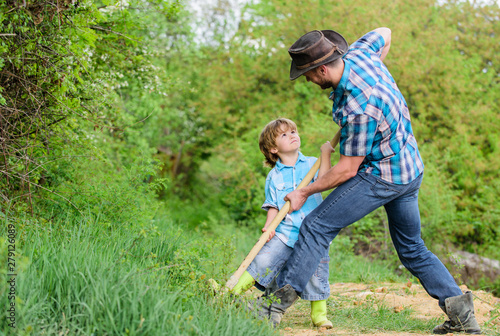 small boy child help father in farming. rich natural soil. Eco farm. Ranch. father and son planting family tree. new life. soils fertilizers. happy earth day. Dig grounf with shovel. Plant in soil